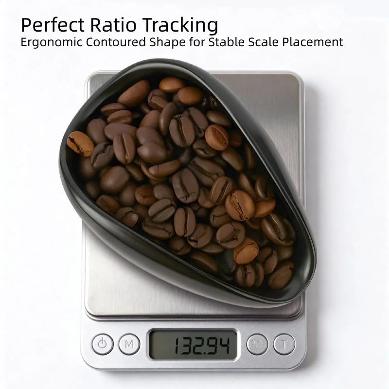 Ceramic coffee dosing dish filled with roasted coffee beans on a digital scale for ratio tracking.