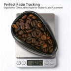 Ceramic coffee dosing dish filled with roasted coffee beans on a digital scale for ratio tracking.