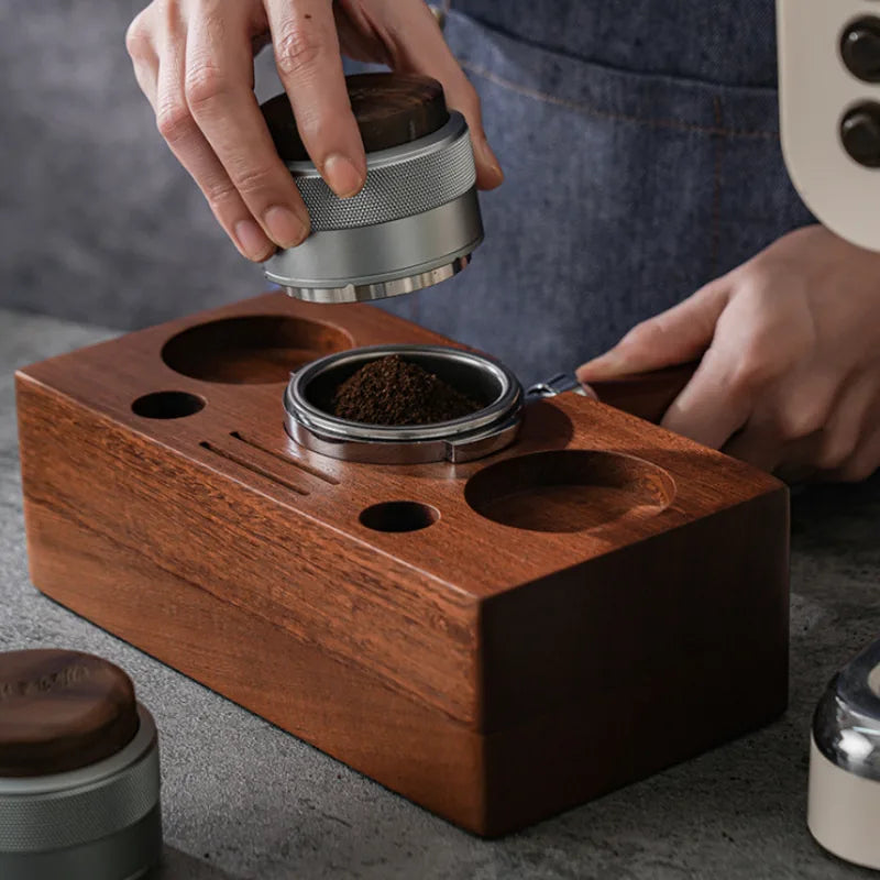 Culturbo silver 2-in-1 walnut wood espresso distributor and calibrated tamper being used by a barista.