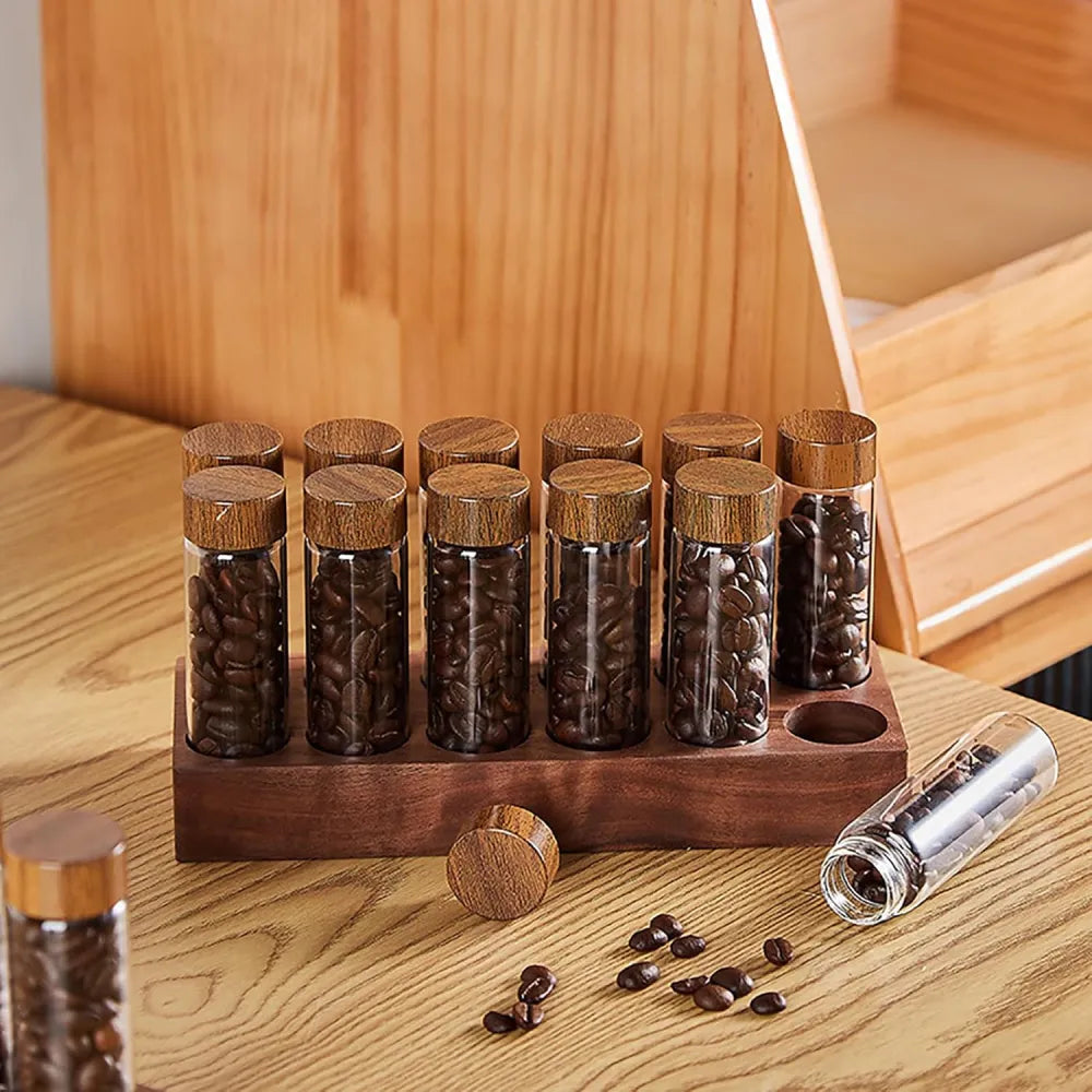 Close up of airtight borosilicate glass coffee bean storage tubes and solid walnut lid.