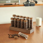 Elegant coffee bar organizer displaying espresso beans in glass vials on walnut base.