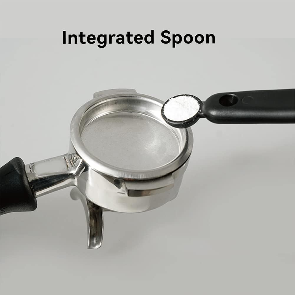Detailed view of the espresso brush handle tail featuring a built-in measuring spoon scooping white espresso machine cleaning powder.