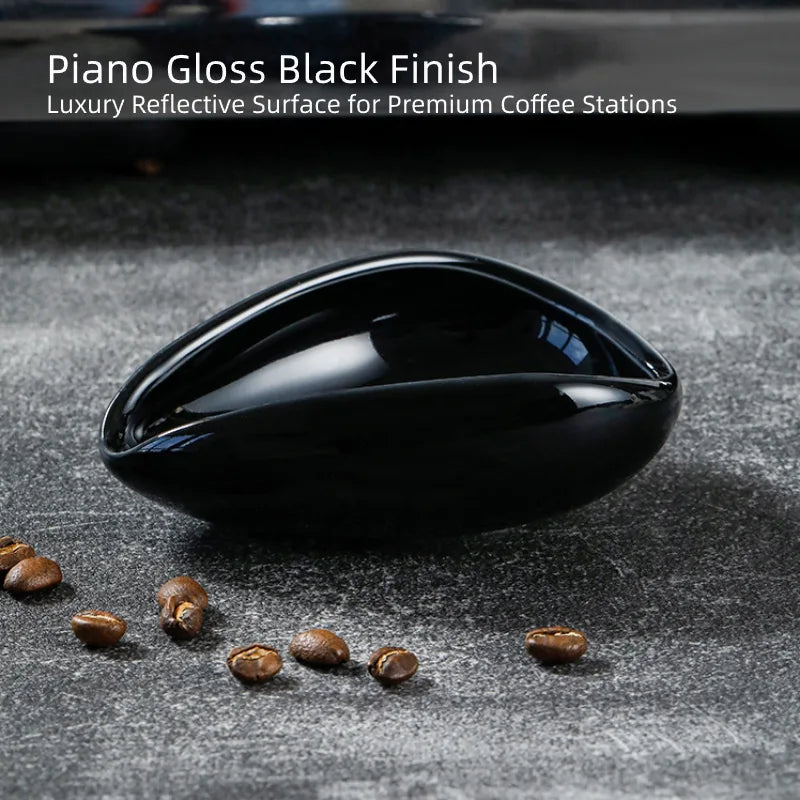 High-gloss piano black ceramic coffee bean single dose cup reflection on a minimalist coffee bar.