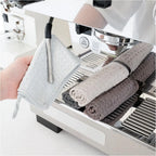 Rolled barista microfiber towels on espresso machine drip tray